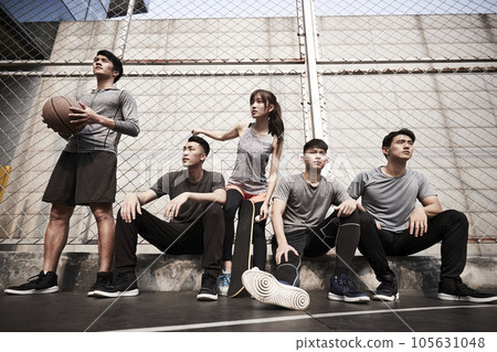 group of five asian young adults men and woman resting relaxing on outdoor basketball court group of five asian young adults men and woman resting relaxing on outdoor basketball court 105631048