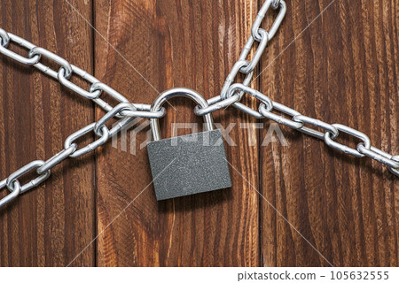 Padlock and chain on wooden background.  105632555