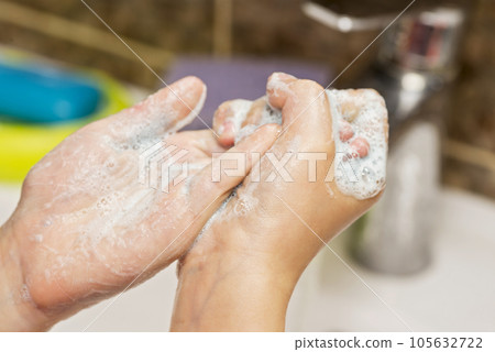 Kid is washing his hands in bathroom. Kid is washing his hands in bathroom. 105632722