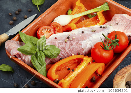 Raw uncooked meat tenderloin in a baking dish. Raw uncooked meat tenderloin in a baking dish. 105634291