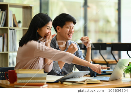 Two cheerful college students celebrating success together. Friendship, community and university concept. 105634304