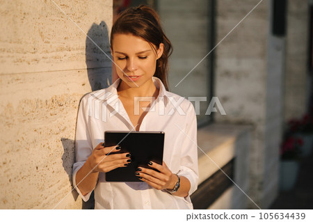 Portrait of woman using tablet outdoors. Female working on digital tablet 105634439