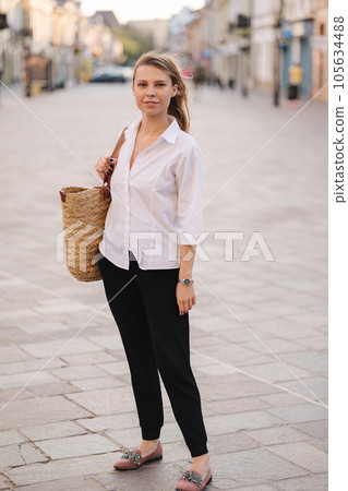 Attractive woman walking in centre of city. Happy female go home after work 105634488