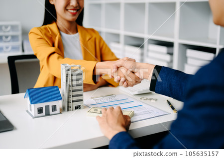 Buying a home or insurance deal, an insurance agent pointing a pen to those interested in renting a house, a contract, signing an Home buying agreement in modern office. Buying a home or insurance deal, an insurance agent pointing a pen to those interested in renting a house, a contract, signing an Home buying agreement in modern office. 105635157