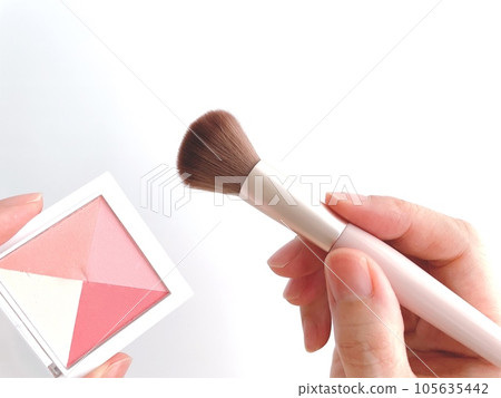 Woman's hand with blush and makeup brush 105635442