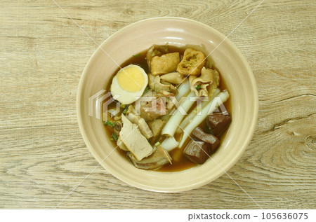Chinese rice flour paste with pork and entrails topping creamy egg yolk in soup on bowl 105636075