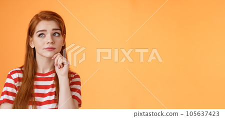Close-up uneasy cute redhead female student facing tough troublesome decision, thinking intense, look upper left corner thoughtful touch chin, pondering between choices, frown focused 105637423
