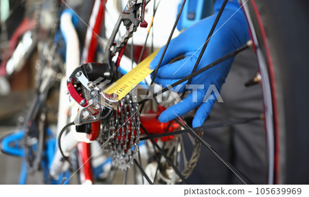 Close-up of male hands using measure tape for problem identification 105639969