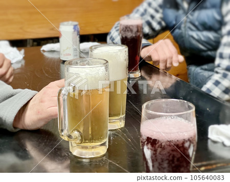 一張桌子,上面有啤酒杯、果汁和罐裝飲料,還有一個人 一張桌子,上面有啤酒杯、果汁和罐裝飲料,還有一個人 105640083