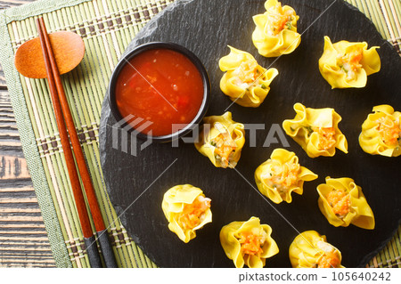Shumai is a type of traditional Chinese dumpling filled with shrimp or crab, dim sum closeup. Horizontal top view 105640242