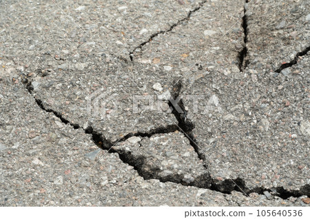 Selective focus on broken pavement road.Broken pavement road background and texture. Selective focus on broken pavement road.Broken pavement road background and texture. 105640536