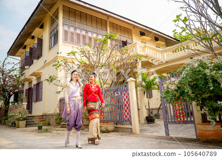 Two young Asian women walk together in front of public ancient house in northern of Thailand Two young Asian women walk together in front of public ancient house in northern of Thailand 105640789