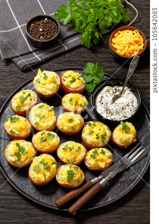 baked stuffed red potatoes on black plate baked stuffed red potatoes on black plate 105642085