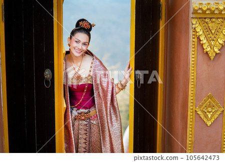 Portrait of beautiful Asian woman wear Thai traditional dress stand in area of ancient door Portrait of beautiful Asian woman wear Thai traditional dress stand in area of ancient door 105642473