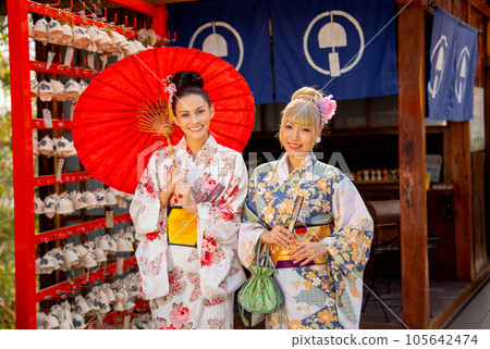 Close up two Asian women wear japanese style dress with one hold red umbrella and stand together 105642474