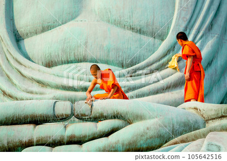 Two young Asian monk stay with other monk on green big buddha statue to clean in area of body statue 105642516