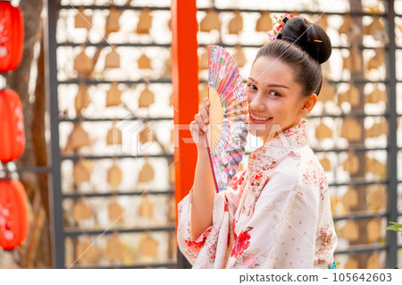Portrait of pretty young woman wear japanese style dress and hold fan also look at camera Portrait of pretty young woman wear japanese style dress and hold fan also look at camera 105642603