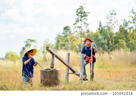 Asian senior man use Thai rice crackers and work together also support by Asian woman Asian senior man use Thai rice crackers and work together also support by Asian woman 105642818