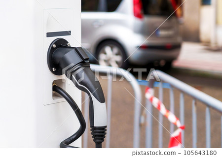Electric plug of green renewable energy car charging station in the city Electric plug of green renewable energy car charging station in the city 105643180