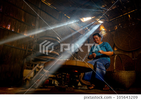 Asian young senior woman prepare raw material silk in room with beam of sunlight and work alone Asian young senior woman prepare raw material silk in room with beam of sunlight and work alone 105643209