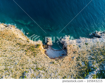 Top view of a beautiful sea harbor. Lagoon with dark blue water. Waves near rocky coast and boat Top view of a beautiful sea harbor. Lagoon with dark blue water. Waves near rocky coast and boat 105643215