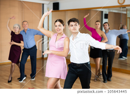 Young pair practicing ballroom dance in dance studio Young pair practicing ballroom dance in dance studio 105643445