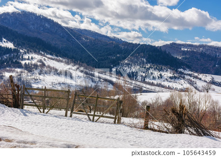 carpathian rural landscape i winter. wooden fence on the snow covered hill. bright sunny day 105643459