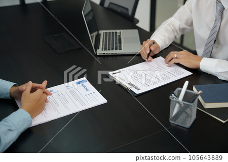 Examiner reading a resume during job interview at office Business and human resources concept. Examiner reading a resume during job interview at office Business and human resources concept. 105643889