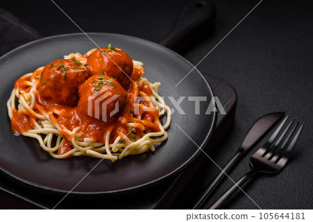 Delicious fresh meatballs and pasta in tomato sauce with salt, spices and herbs Delicious fresh meatballs and pasta in tomato sauce with salt, spices and herbs 105644181