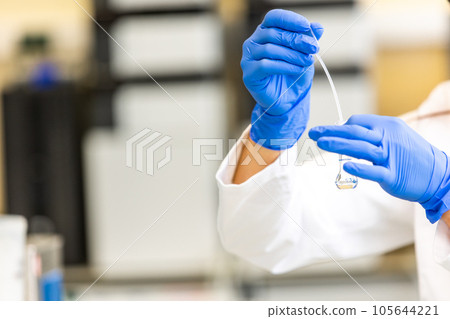 Young woman scientist in a research laboratory creating a scientific experiment, laboratory concept 105644221