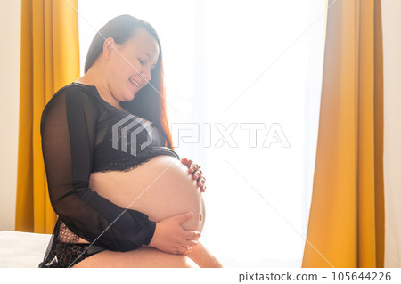 Young pregnant woman smilling to a belly, pregnancy concept 105644226