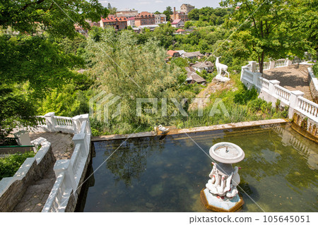 Kamianets-Podilskyi cityscape with swan lake in city park, Ukraine. Kamianets-Podilskyi cityscape with swan lake in city park, Ukraine. 105645051