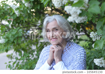 Portrait of happy senior beautiful woman on lilacs background 105645130