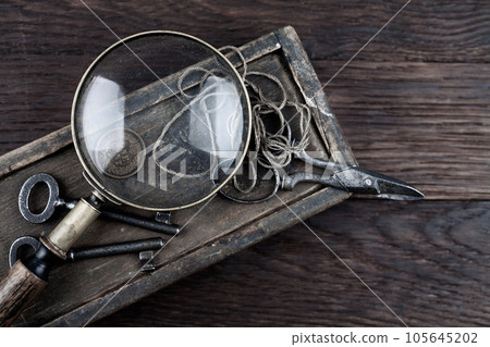Antique wooden box, old vintage retro scissors and magnifying glass. 105645202