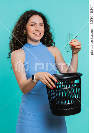 Woman taking off, throwing out glasses into bin after medical vision laser treatment therapy surgery 105646364