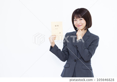 Business woman in her thirties thinking with a smile holding a salary bag in front of a white background 105646828
