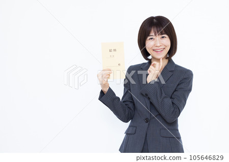 Business woman in her thirties thinking with a smile holding a salary bag in front of a white background 105646829