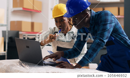 African american employees reading products on laptop and looking at goods packed in cardboard boxes in depot. Warehouse manager and worker checking stock logistics, small business. Handheld shot. African american employees reading products on laptop and looking at goods packed in cardboard boxes in depot. Warehouse manager and worker checking stock logistics, small business. Handheld shot. 105646932