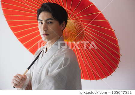 A man in a kimono, a Japanese umbrella 105647531