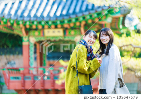 Young woman enjoying sightseeing with friends 105647579