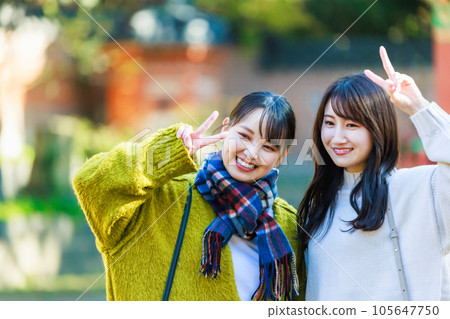 Young woman enjoying sightseeing with friends Young woman enjoying sightseeing with friends 105647750