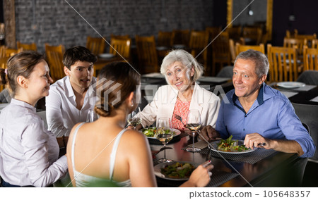Happy senior couple meeting with adult children in restaurant 105648357