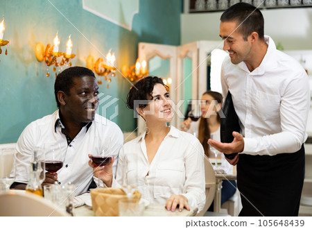 Waiter serving couple at restaurant Waiter serving couple at restaurant 105648439