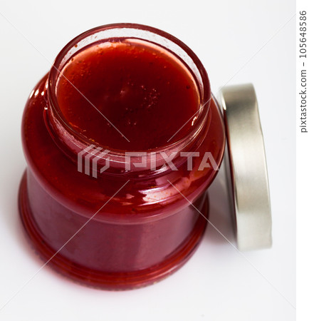 Glass jar of strawberry jam, closeup 105648586