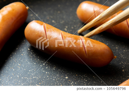 烹飪場景，將維也納香腸切入煎鍋中烘烤。 105649796