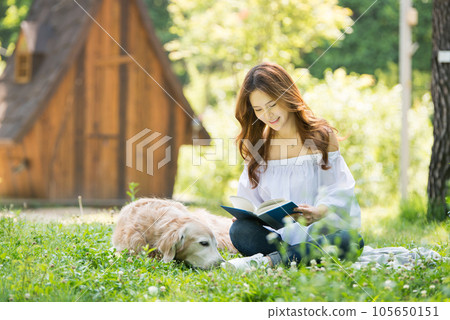 a happy young woman taking a walk with her dog in the park a happy young woman taking a walk with her dog in the park 105650151