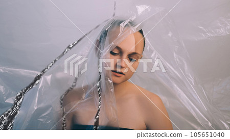 Information leak. Personal data security. Brainwashing influence. Glitch noise flow over tired disappointed woman head isolated with plastic polyethylene film. Information leak. Personal data security. Brainwashing influence. Glitch noise flow over tired disappointed woman head isolated with plastic polyethylene film. 105651040