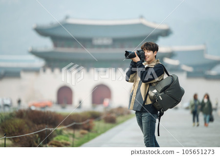A young man holding a camera and taking pictures during a trip to Korea A young man holding a camera and taking pictures during a trip to Korea 105651273