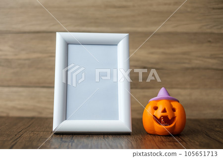 Orange pumpkin on table and frame with copy space for text. Happy Halloween day, Hello October, fall autumn season, Festive, party and holiday concept Orange pumpkin on table and frame with copy space for text. Happy Halloween day, Hello October, fall autumn season, Festive, party and holiday concept 105651713