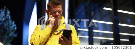 Puzzled tourist looks at his smartphone screen in the street. 105652308